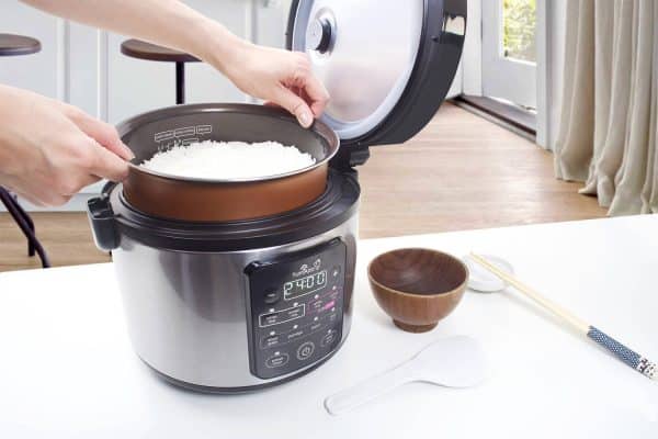 Kumo rice cooker with lid open lifting out cooked rice